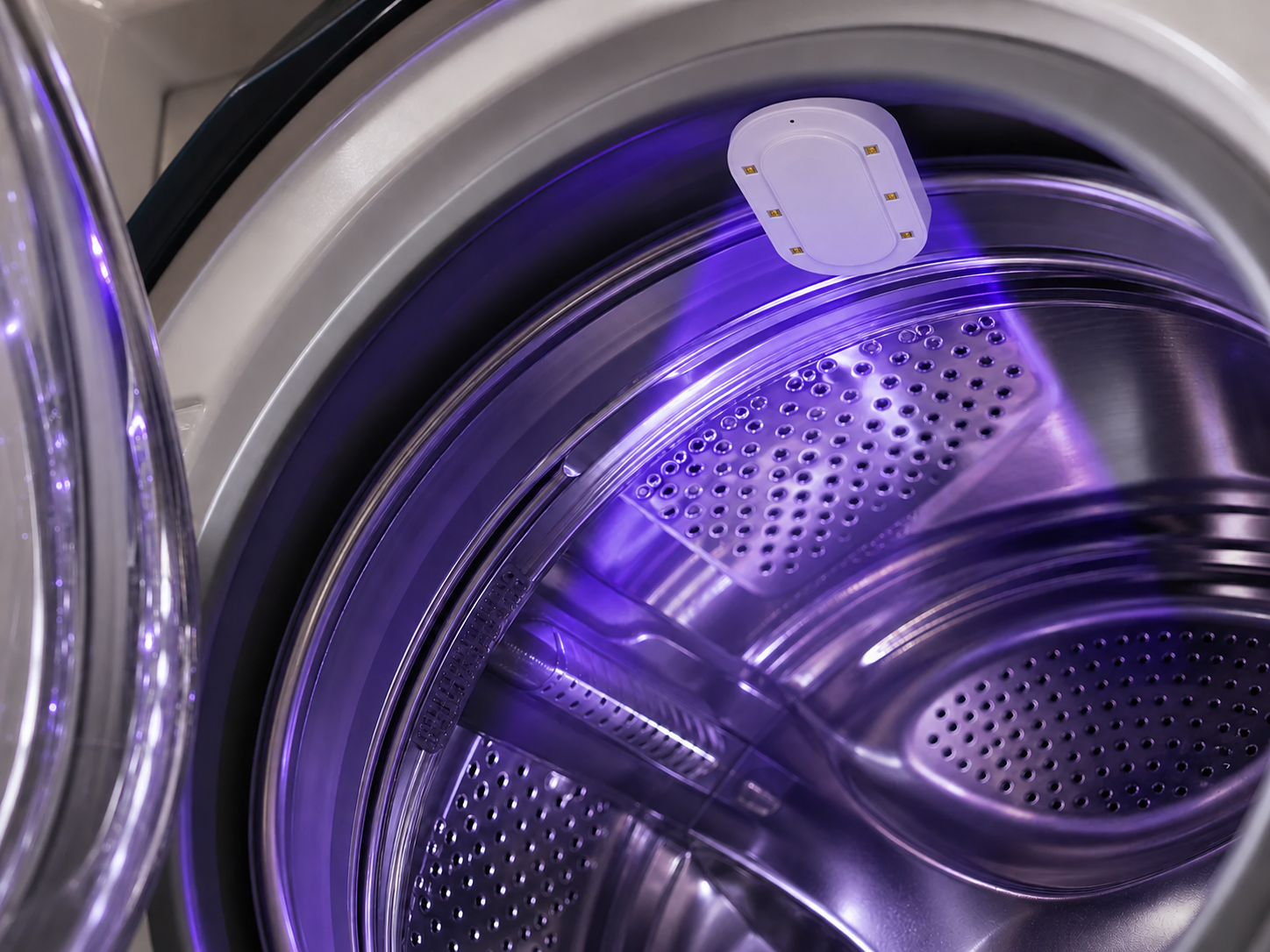 Azuremist refresh device casting purple light inside a washing machine drum